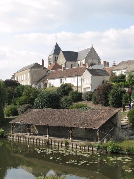 Photographie réaliste en haute résolution montrant l'entrée d'une maison individuelle avec une fenêtre en aluminium moderne et un volet roulant, dans un environnement résidentiel typique de la région du Loiret. La maison est entourée d'un jardin ou d'une cour, avec des arbres ou verdure environnante. L'image doit montrer clairement les menuiseries extérieures (fenêtres et volets) comme point focal, illustrant le type de travail réalisé par CEEN Menuiserie. Photographie de jour, prise depuis la rue ou l'accès résidentiel, sans texte ni logo.